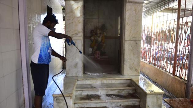 A resident of RP Nagar, Matunga Labour Camp near Dharavi cleans the Hanuman Mandir platform at Shankeshwar Shiv Mandir complex with soap water. BMC has identified Rajiv Gandhi Sports Club in Dharavi to be turned into a 300-bed quarantine facility. Additional commissioner (health), BMC, Suresh Kakani said they are also searching for hotels that could be turned into isolation wards. (Anshuman Poyrekar / HT Photo) A resident of RP Nagar, Matunga Labour Camp near Dharavi cleans the Hanuman Mandir platform at Shankeshwar Shiv Mandir complex with soap water. BMC has identified Rajiv Gandhi Sports Club in Dharavi to be turned into a 300-bed quarantine facility. Additional commissioner (health), BMC, Suresh Kakani said they are also searching for hotels that could be turned into isolation wards. (Anshuman Poyrekar / HT Photo)