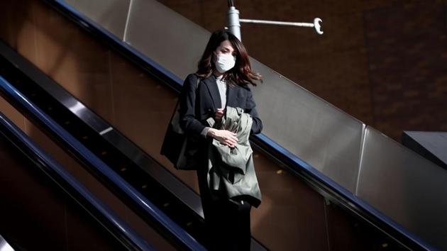 A woman wearing a face mask amid concerns over the spread of the coronavirus, uses an escalator at a department store in Tokyo on April 7. A month-long emergency was declared in Tokyo over a spike in coronavirus cases in the country. (Behrouz Mehri / AFP) A woman wearing a face mask amid concerns over the spread of the coronavirus, uses an escalator at a department store in Tokyo on April 7. A month-long emergency was declared in Tokyo over a spike in coronavirus cases in the country. (Behrouz Mehri / AFP)
