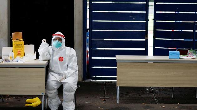 A healthcare worker wearing protective gear waits to test people for the coronavirus disease (COVID-19) outside a stadium in Bogor, West Java province, Indonesia.(REUTERS)