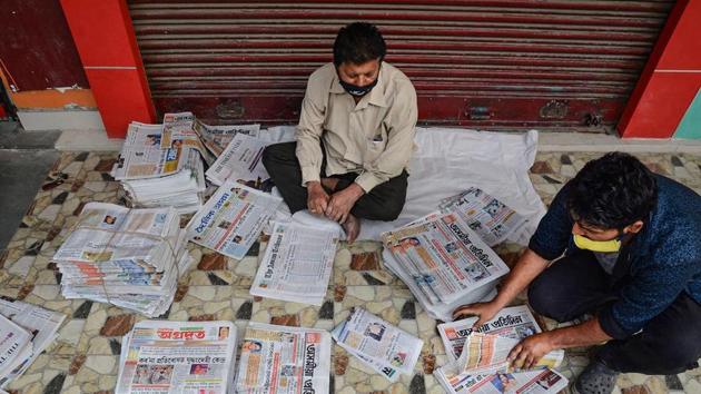 Vendors arrange different vernacular newspaper before delivering it to customers during the nationwide lockdown amid coronavirus pandemic, at Ganeshguri in Guwahati.(PTI Photo)