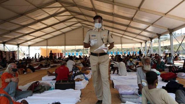A policeman wearing a protective mask walks inside a shelter set up for migrants during a 21-day nationwide lockdown to limit the spreading of coronavirus disease (COVID-19) in Mumbai (Reuters) A policeman wearing a protective mask walks inside a shelter set up for migrants during a 21-day nationwide lockdown to limit the spreading of coronavirus disease (COVID-19) in Mumbai (Reuters)
