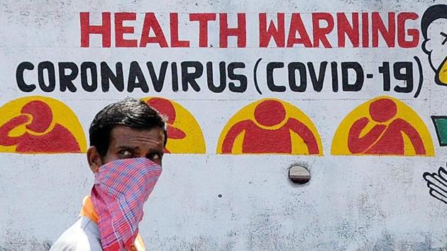 A man wearing a protective mask walks past a walking graffiti during a nationwide lockdown imposed in the wake of coronavirus pandemic, in Mumbai(ANI Photo)