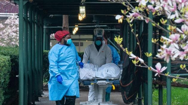 A Kingsbrook Jewish Medical Center employees transport a deceased patient to a refrigerated truck on April 8, 2020 in the Brooklyn borough of New York City.(AFP) A Kingsbrook Jewish Medical Center employees transport a deceased patient to a refrigerated truck on April 8, 2020 in the Brooklyn borough of New York City.(AFP)