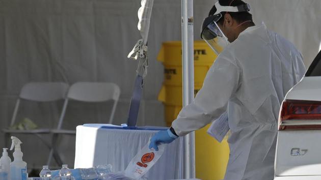 A fireman prepares a sample taken from a person during the second stage of a COVID-19 test. (AP) A fireman prepares a sample taken from a person during the second stage of a COVID-19 test. (AP)