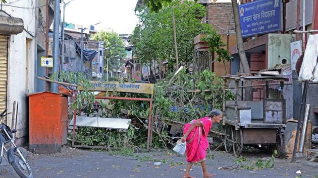 An elderly woman walks past a barrier put up by Pune administration on Laxmi road in Raviwar peth area where curfew has been imposed, on Tuesday. (RAVINDRA JOSHI/HT) An elderly woman walks past a barrier put up by Pune administration on Laxmi road in Raviwar peth area where curfew has been imposed, on Tuesday. (RAVINDRA JOSHI/HT)