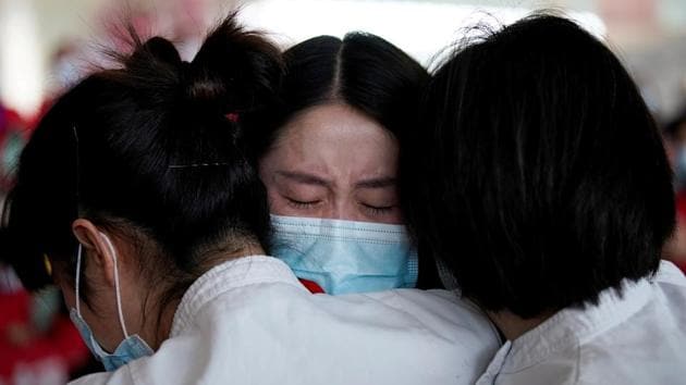 Medical workers hug at Tianhe International Airport after travel restrictions to leave Wuhan, the capital of Hubei province and China's epicentre of the novel coronavirus disease Covid-19 outbreak, were lifted, on April 8.(Reuters Photo)