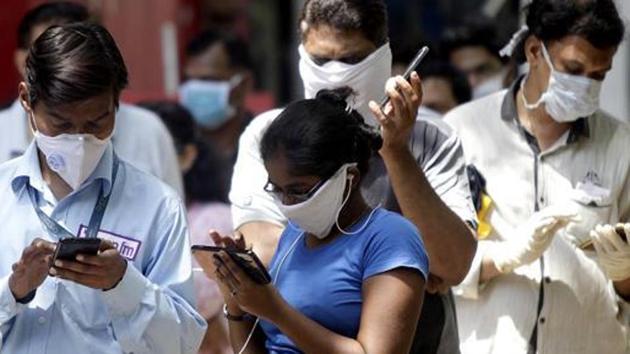 People in protective masks buying essentials during the nationwide lockdown in Mumbai.(ANI PHOTO.)