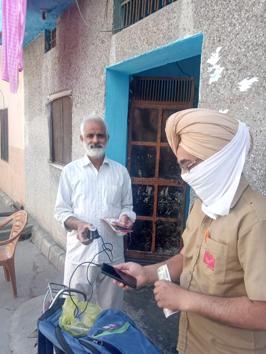 A postman verifying a beneficiary’s identity before handing him over his pension in Ludhiana on Tuesday (HT PHOTO) A postman verifying a beneficiary’s identity before handing him over his pension in Ludhiana on Tuesday (HT PHOTO)