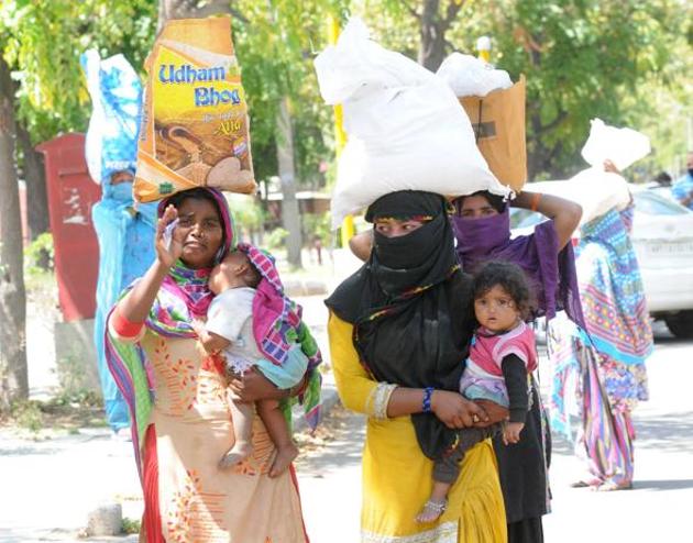 Migrants stuck at Muali Jagran carrying back ration that was distributed by Good Samaritans in Chandigarh on Thursday. (Keshav Singh/HT) Migrants stuck at Muali Jagran carrying back ration that was distributed by Good Samaritans in Chandigarh on Thursday. (Keshav Singh/HT)