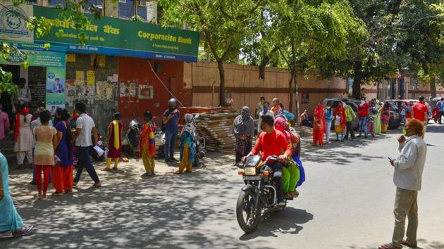 People wait outside a bank for financial transactions during the nationwide lockdown imposed in view of the coronavirus pandemic, in New Delhi on Wednesday.(PTI Photo) People wait outside a bank for financial transactions during the nationwide lockdown imposed in view of the coronavirus pandemic, in New Delhi on Wednesday.(PTI Photo)