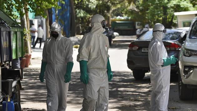 South Delhi Municipal Corporation (SDMC) public health department field workers with Personal Protective Equipment (PPE) arrives along with a team of doctors and inspectors, to chemically disinfect the residence where three persons were tested positive for Covid-19, during a sanitization drive, on day thirteen of the 21-day nationwide lockdown to curb the spread of Coronavirus.(Burhaan Kinu/HT PHOTO)