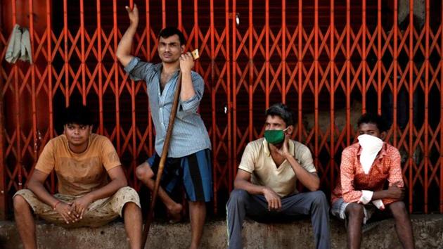 Migrant workers, who work in textile looms, are seen outside a loom after it was shut due to the 21-day nationwide lockdown to slow the spread of the coronavirus disease, in Bhiwandi on the outskirts of Mumbai.(REUTERS)
