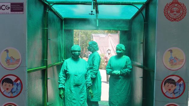 Medical staff in protective gear walk through a disinfecting tunnel outside Civil Hospital Sector 10 of Gurugram. (Yogendra Kumar/HT PHOTO) Medical staff in protective gear walk through a disinfecting tunnel outside Civil Hospital Sector 10 of Gurugram. (Yogendra Kumar/HT PHOTO)