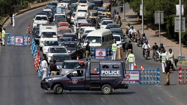 Police officers check drivers' documents to verify the purpose of movement at a blocked road, during Covid-19 triggered lockdown in Karachi, Pakistan on April 9. (Reuters Photo) Police officers check drivers' documents to verify the purpose of movement at a blocked road, during Covid-19 triggered lockdown in Karachi, Pakistan on April 9. (Reuters Photo)