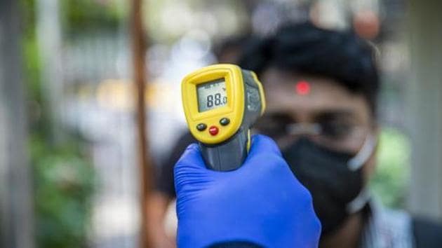 An office worker wearing a protective mask is screened with an infrared thermometer as he enters a building, New Delhi, March 11, 2020(Bloomberg) An office worker wearing a protective mask is screened with an infrared thermometer as he enters a building, New Delhi, March 11, 2020(Bloomberg)