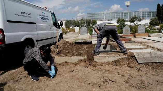 A relative of a person who died of COVID-19 reacts as a funerary worker closes the grave at the Spanish Muslim military cemetery during a burial, in Grinon, Spain. The agony of a death is compounded by the inability of families and relatives to either properly attend or participate in the last rites. (Juan Medina / REUTERS) A relative of a person who died of COVID-19 reacts as a funerary worker closes the grave at the Spanish Muslim military cemetery during a burial, in Grinon, Spain. The agony of a death is compounded by the inability of families and relatives to either properly attend or participate in the last rites. (Juan Medina / REUTERS)