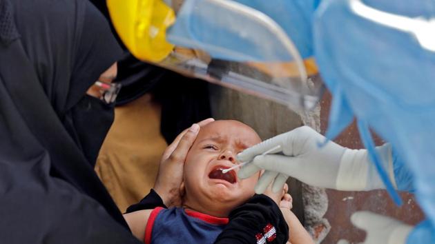 A child cries as a doctor wearing protective gear takes a swab from him to test for coronavirus disease (COVID-19) at a residential area in Ahmedabad, India, April 8, 2020.(REUTERS)