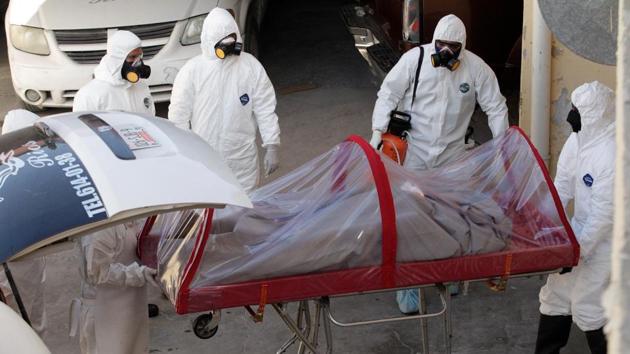Funeral workers in personal protective equipment (PPE) suits remove the body of a COVID-19 victim from a hearse at a funeral parlour, in Ciudad Juarez, Mexico. Across the globe, wrenching scenes are playing out in hospitals and funeral homes struggling to cope with the coronavirus dead. (Jose Luis Gonzalez / REUTERS) Funeral workers in personal protective equipment (PPE) suits remove the body of a COVID-19 victim from a hearse at a funeral parlour, in Ciudad Juarez, Mexico. Across the globe, wrenching scenes are playing out in hospitals and funeral homes struggling to cope with the coronavirus dead. (Jose Luis Gonzalez / REUTERS)