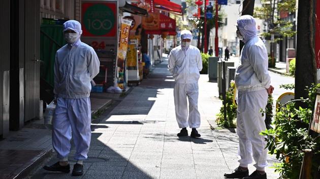 Employees of a restaurant wearing masks stand outside their eatery before it opens in the Chinatown area in Yokohama on April 9, 2020. (AFP photo) Employees of a restaurant wearing masks stand outside their eatery before it opens in the Chinatown area in Yokohama on April 9, 2020. (AFP photo)
