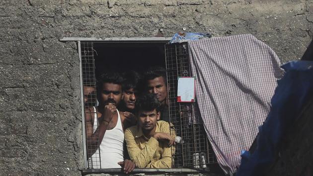 Migrant workers from other states look through the window of a room in Dharavi, one of Asia's largest slums, during lockdown to prevent the spread of the new coronavirus in Mumbai. (AP) Migrant workers from other states look through the window of a room in Dharavi, one of Asia's largest slums, during lockdown to prevent the spread of the new coronavirus in Mumbai. (AP)