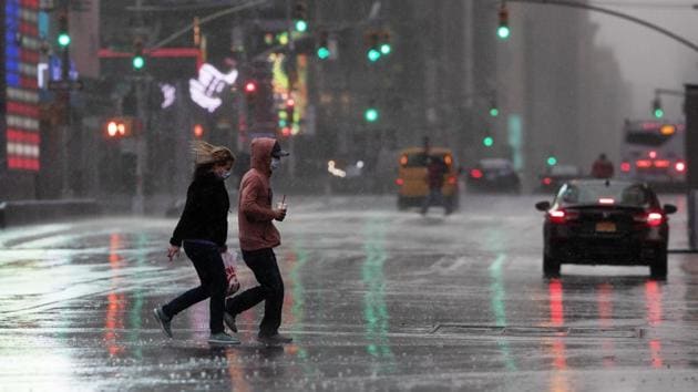 Times Square is quiet as people jog through a rain storm during the coronavirus pandemic in New York.(AP Photo)