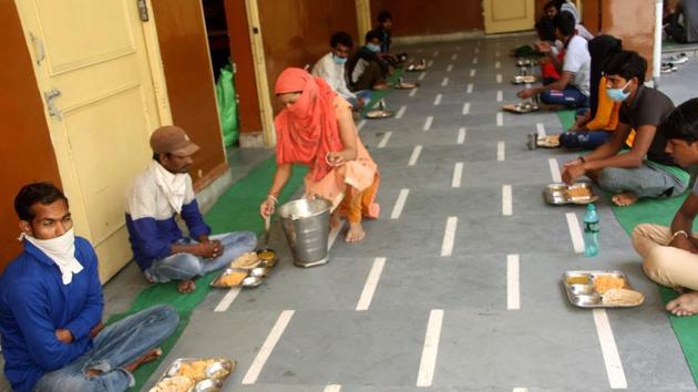 A volunteer serving food to migrant labourers at a shelter home in Rohtak. (Manoj Dhaka/HT) A volunteer serving food to migrant labourers at a shelter home in Rohtak. (Manoj Dhaka/HT)