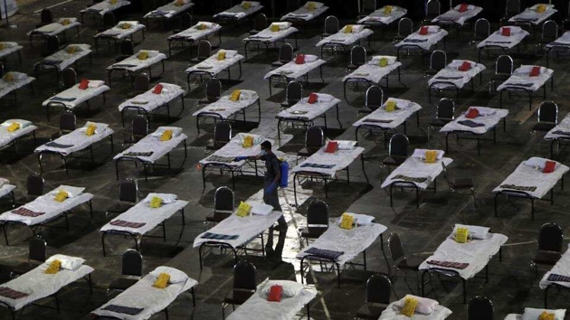 A civic worker sprays disinfectant on beds at a special temporary hospital facility for COVID-19 patients in Mumbai. (AP) A civic worker sprays disinfectant on beds at a special temporary hospital facility for COVID-19 patients in Mumbai. (AP)