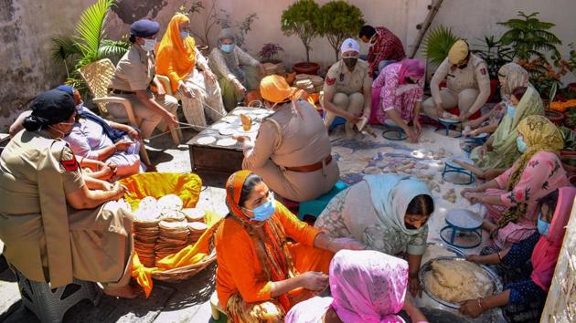 Punjab Police personnel prepare food in a community kitchen to serve the needy during the nationwide lockdown, imposed as a preventive measure against the coronavirus outbreak, in Amritsar.(PTI)