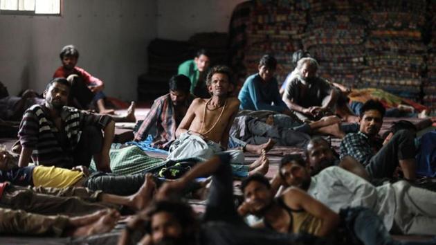 Daily wage workers and homeless people watch television inside a government-run night shelter during a 21-day nationwide lockdown to limit the spreading of coronavirus disease (Covid-19), in the old quarters of Delhi.(REUTERS)