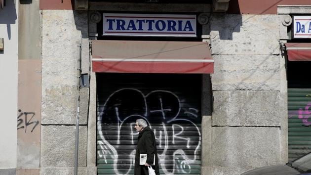 In this April 2, 2020 file photo, a man walks past a closed restaurant following Italy's lockdown measure to contain the spread of COVID-19, in Milan, Italy. (AP) In this April 2, 2020 file photo, a man walks past a closed restaurant following Italy's lockdown measure to contain the spread of COVID-19, in Milan, Italy. (AP)