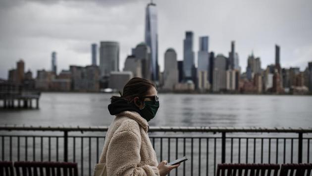The downtown New York City skyline looms over pedestrians wearing masks due to COVID-19 concerns, Friday, April 10, 2020, in Jersey City, N.J. (AP) The downtown New York City skyline looms over pedestrians wearing masks due to COVID-19 concerns, Friday, April 10, 2020, in Jersey City, N.J. (AP)