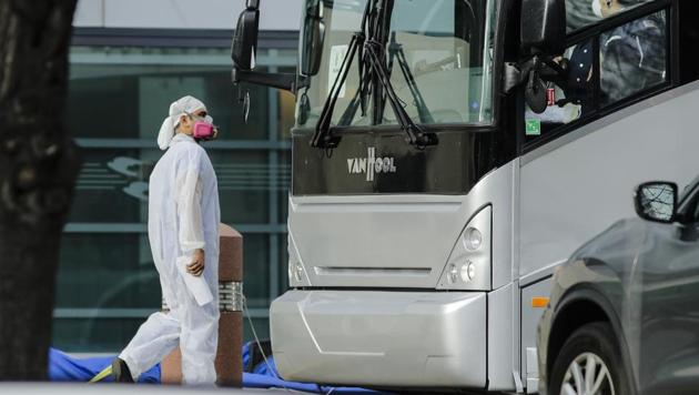 A medical worker and a bus driver wear personal protective equipment outside of Kings County hospital Friday, April 10, 2020, in the Brooklyn borough of New York. (AP)