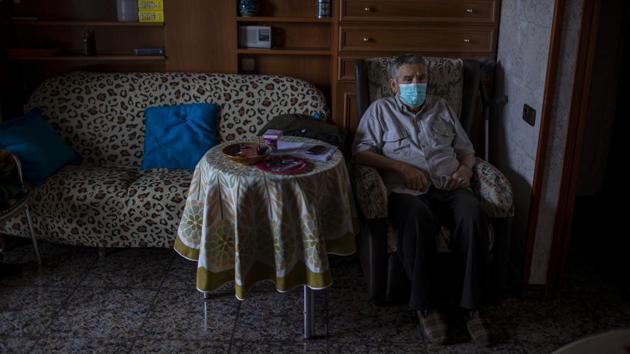 Vicente Lopez, 65, sits at his house waiting to be examined by a doctor. Lopez is under quarantine because his partner tested positive for COVID-19 and is in the hospital. Lopez relies on a neighbour to deliver groceries and basic supplies. (Emilio Morenatti / AP) Vicente Lopez, 65, sits at his house waiting to be examined by a doctor. Lopez is under quarantine because his partner tested positive for COVID-19 and is in the hospital. Lopez relies on a neighbour to deliver groceries and basic supplies. (Emilio Morenatti / AP)