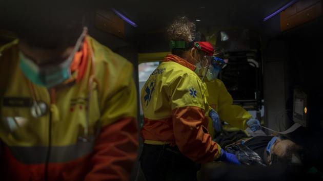 Paramedics tend to a patient who doesn’t have COVID-19 inside an ambulance. Medical crews have been doing extra duty during the coronavirus pandemic, checking on patients who are positive and not. (Emilio Morenatti / AP) Paramedics tend to a patient who doesn’t have COVID-19 inside an ambulance. Medical crews have been doing extra duty during the coronavirus pandemic, checking on patients who are positive and not. (Emilio Morenatti / AP)