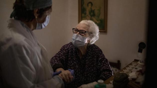 Pepita Jove Puiggros, 92, holds the hand of home care nurse Laura Valdes during a visit. Puiggros lives alone and receives food deliveries from a social service agency three days a week, but the deliveries have become more unpredictable amid the coronavirus pandemic. (Emilio Morenatti / AP) Pepita Jove Puiggros, 92, holds the hand of home care nurse Laura Valdes during a visit. Puiggros lives alone and receives food deliveries from a social service agency three days a week, but the deliveries have become more unpredictable amid the coronavirus pandemic. (Emilio Morenatti / AP)