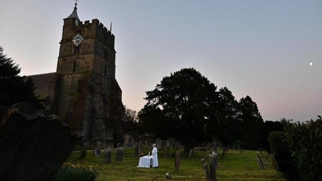 The Vicar of Brenchley Reverend Campbell Paget conducts an Easter Service at dawn in the churchyard of All Saints’ Church in Brenchley, England, adhering to government advice on social distancing. People were urged by the government to respect lockdown measures by celebrating the holiday in their homes. (Ben Stansall / AFP)