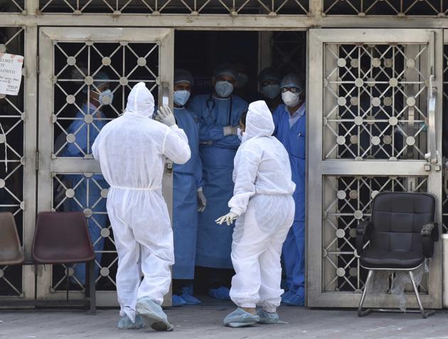 CATS ambulance staff in PPE suits and doctors of LNJP Hospital during an altercation outside the special coronavirus screening center, on day eighteen of the 21 day lockdown to limit the coronavieus, at LNJP Hospital in New Delhi on Saturday.(Sonu Mehta/HT PHOTO)