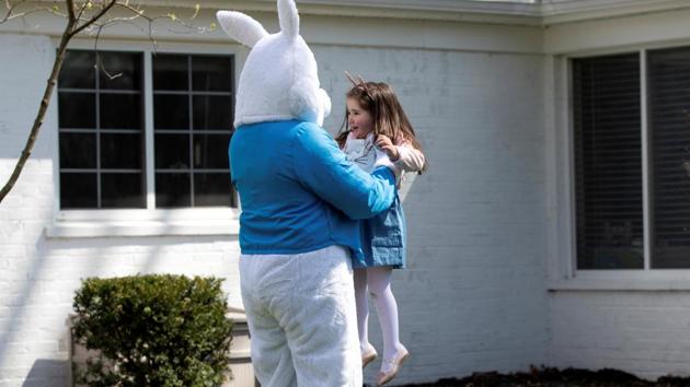 Genevieve Pina, 3, smiles as a person dressed as an Easter bunny surprises her in their backyard, amid the ongoing coronavirus outbreak, in Plymouth, Michigan, US on April 11. (Emily Elconin / REUTERS)