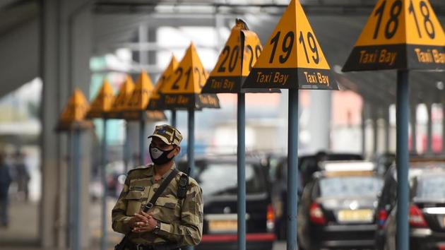 A security personnel wearing a facemask amid concerns over the spread of the COVID-19 novel coronavirus, stands guard outside at the Indira Gandhi International Airport in New Delhi.(AFP)