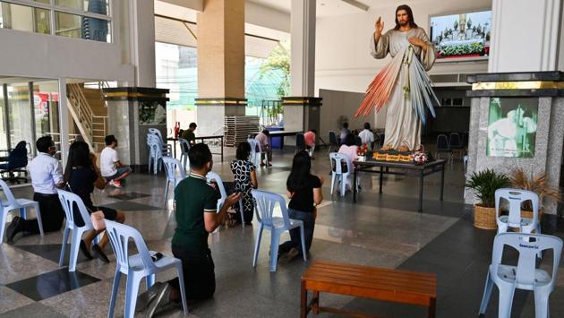 Roman Catholic devotees wearing face masks observe social distancing as they pray during an Easter Sunday mass at the Holy Redeemer Church in Bangkok, Thailand. The church cancelled the traditional Easter celebration of handing out decorated eggs while mass was broadcast on a livestream. (Romeo Gacad / AFP)