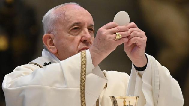 Pope Francis holds the Holy Bread as he celebrates the Eucharist during Easter Sunday Mass on April 12, 2020 behind closed doors at St. Peter’s Basilica in The Vatican. The 83-year-old pontiff’s message to the world, calling for solidarity the world over to confront an “epochal challenge”, was live-streamed for the first time. (Andreas Solaro / AFP)