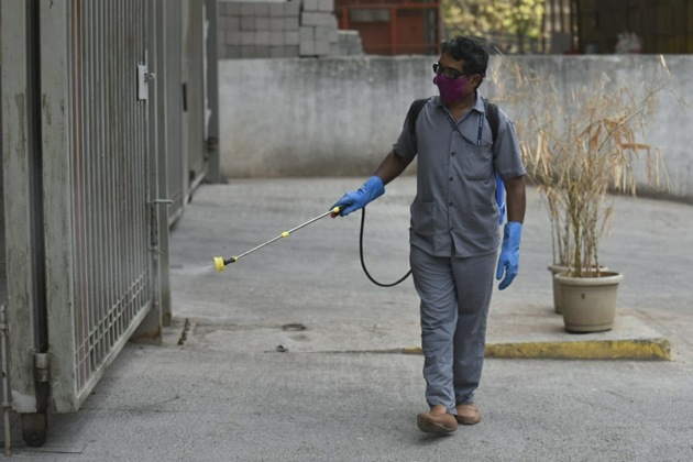 A BMC worker sanitizes the gate of a building in Parel, Mumbai, April 13, 2020.(Aalok Soni / HT Photo) A BMC worker sanitizes the gate of a building in Parel, Mumbai, April 13, 2020.(Aalok Soni / HT Photo)
