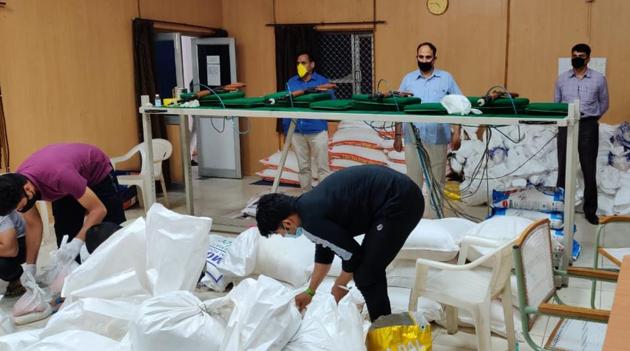 Police officers packing dry ration for needy families inside the commando unit’s target practice room. (Sourced) Police officers packing dry ration for needy families inside the commando unit’s target practice room. (Sourced)