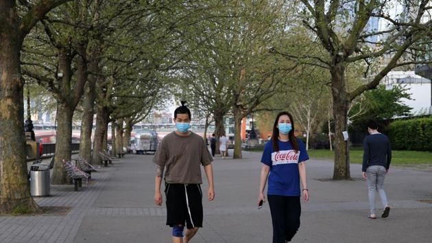 Peopla wearing protective face masks walk on the south bank in London on April 12, 2020, during the nationwide lockdown to combat the novel coronavirus pandemic. - Britain's coronavirus death toll has passed 10,000, after another 737 people died from the virus in the latest count, the health ministry said on Sunday. (AFP) Peopla wearing protective face masks walk on the south bank in London on April 12, 2020, during the nationwide lockdown to combat the novel coronavirus pandemic. - Britain's coronavirus death toll has passed 10,000, after another 737 people died from the virus in the latest count, the health ministry said on Sunday. (AFP)