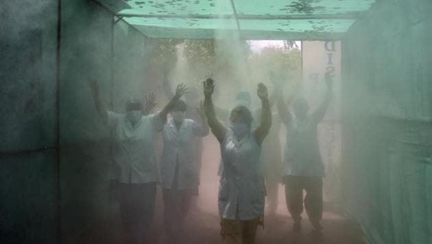 Medical staff walk through a disinfecting tunnel set up by North Delhi Municipal Corporation, on day nineteen of the 21 day nationwide lockdown to check the spread of coronavirus, at the Hindu Rao Hospital, in New Delhi. (Sanjeev Verma/HT PHOTO) Medical staff walk through a disinfecting tunnel set up by North Delhi Municipal Corporation, on day nineteen of the 21 day nationwide lockdown to check the spread of coronavirus, at the Hindu Rao Hospital, in New Delhi. (Sanjeev Verma/HT PHOTO)