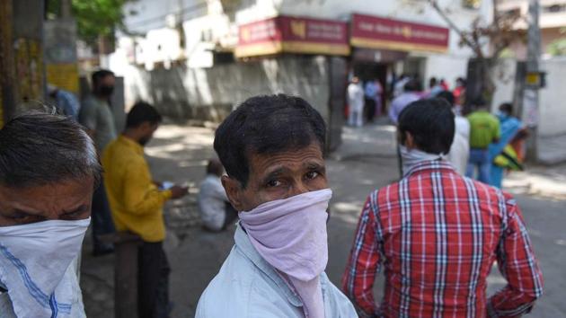 People with their faces covered wait in a queue outside a Punjab National Bank branch in Kirti Nagar, on day twenty of the 21-day nationwide lockdown to curb the spread of coronavirus. (Sanchit Khanna/HT PHOTO) People with their faces covered wait in a queue outside a Punjab National Bank branch in Kirti Nagar, on day twenty of the 21-day nationwide lockdown to curb the spread of coronavirus. (Sanchit Khanna/HT PHOTO)