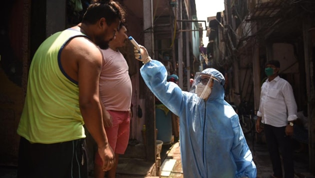 A medical personnel checking residents’ temperature as part of screening process for Covid-19, in Shastri Nagar in Mumbai’s Dharavi , April 14, 2020. (Satish Bate / HT Photo) A medical personnel checking residents’ temperature as part of screening process for Covid-19, in Shastri Nagar in Mumbai’s Dharavi , April 14, 2020. (Satish Bate / HT Photo)