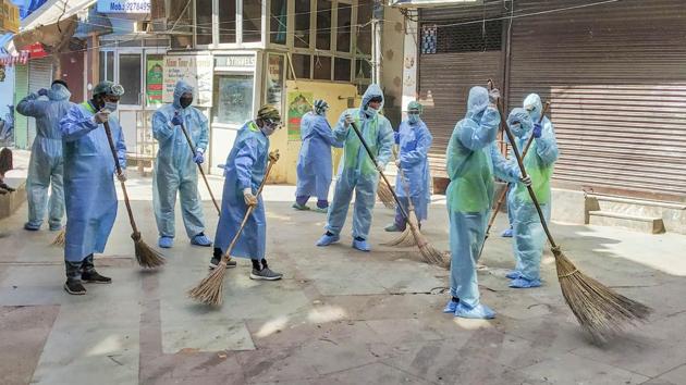 South Delhi Municipal Corporation workers wearing protective suits clean the Nizamuddin residential area in wake of the coronavirus pandemic, in New Delhi, on April 13. (PTI Photo) South Delhi Municipal Corporation workers wearing protective suits clean the Nizamuddin residential area in wake of the coronavirus pandemic, in New Delhi, on April 13. (PTI Photo)