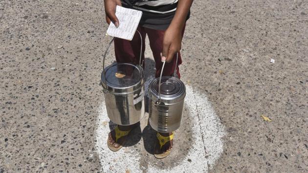 A person waits for his turn inside a marked spot at a free food distribution, by Ramakrishna mission, in New Delhi on April 12. Covid-19 is expected to take a heavy toll on Asia’s third largest economy, which was already in the midst of a slowdown when the virus hit. (Burhaan Kinu / HT Photo)