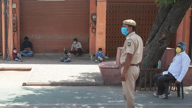 People are seen sitting in front of a closed shop as Police personnel looks on on day nineteen of the 21-day nationwide lockdown to check the spread of coronavirus in Jaipur. (Himanshu Vyas/HT Photo) People are seen sitting in front of a closed shop as Police personnel looks on on day nineteen of the 21-day nationwide lockdown to check the spread of coronavirus in Jaipur. (Himanshu Vyas/HT Photo)